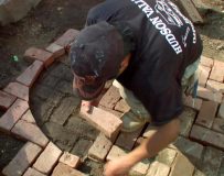A contractor lays pavers for the sidewalk.